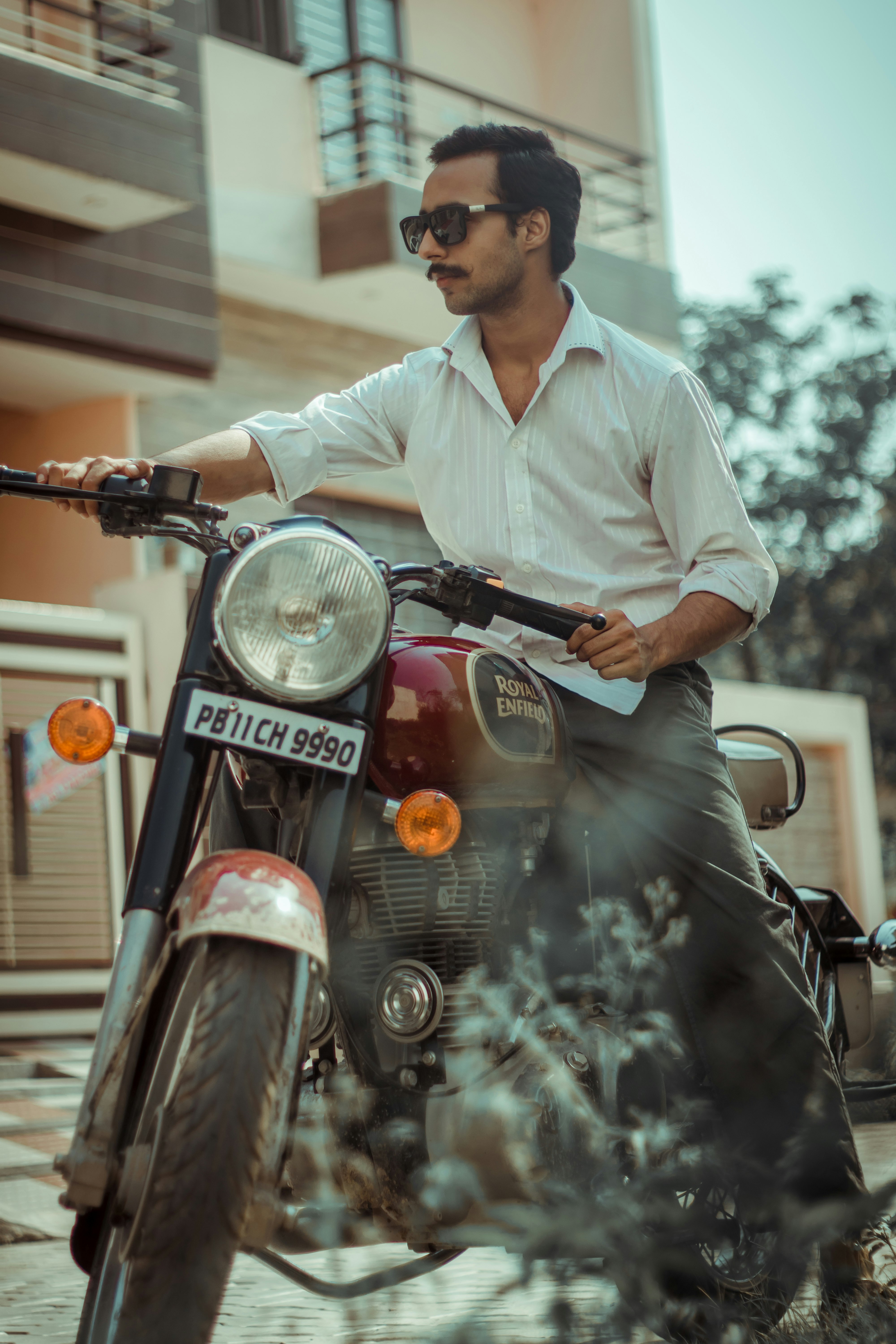 man in white dress shirt riding on red motorcycle during daytime